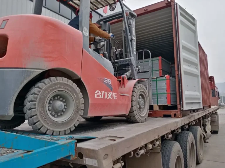 Forklift loading pool slate export crates into a shipping container