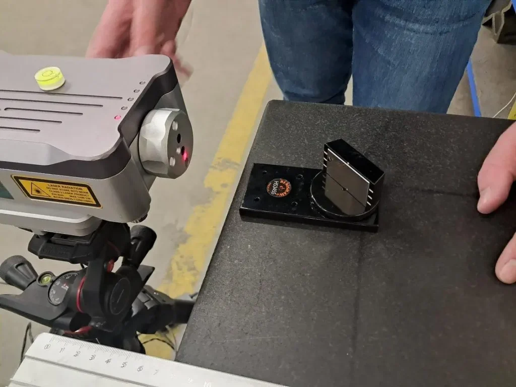 Laser measurement system scanning a billiard slate surface for flatness inspection