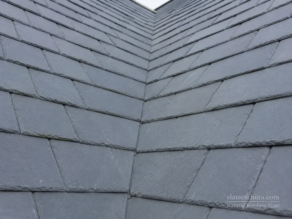 Closed valley detail on a natural slate roof with accurately cut slate edges and concealed valley flashing.
