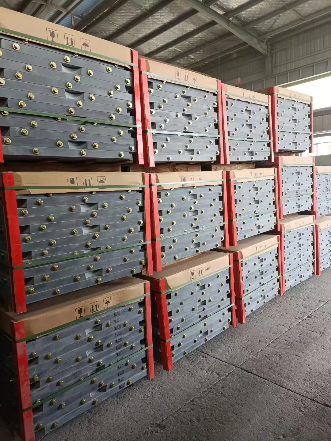 Billiard table slate set packed in a heavy-duty export crate Three machined billiard table slate panels standing upright in a wooden export crate with timber dividers and drilled holes visible