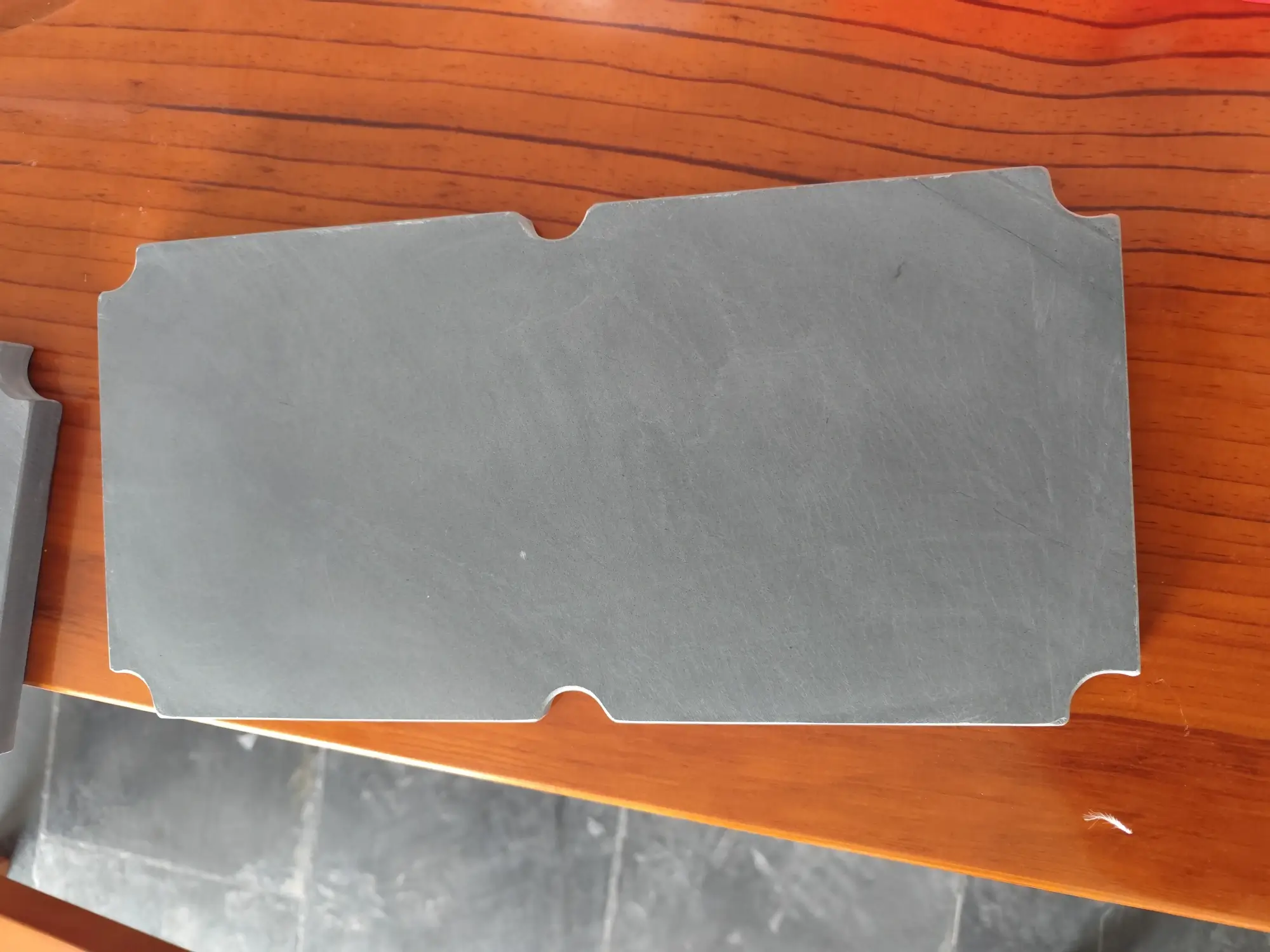 Machined billiard slate trial sample close-up Machined billiard slate trial sample with drilled holes and a bevelled joint edge in close-up
