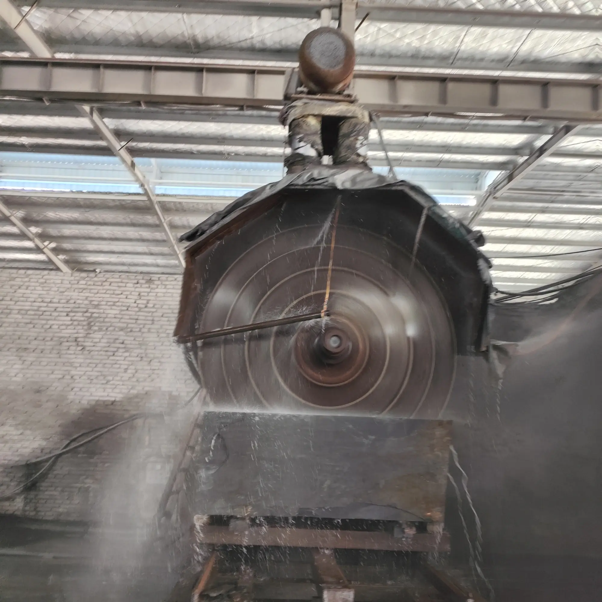 Large CNC bridge gantry machine machining a grey slate panel in a factory workshop