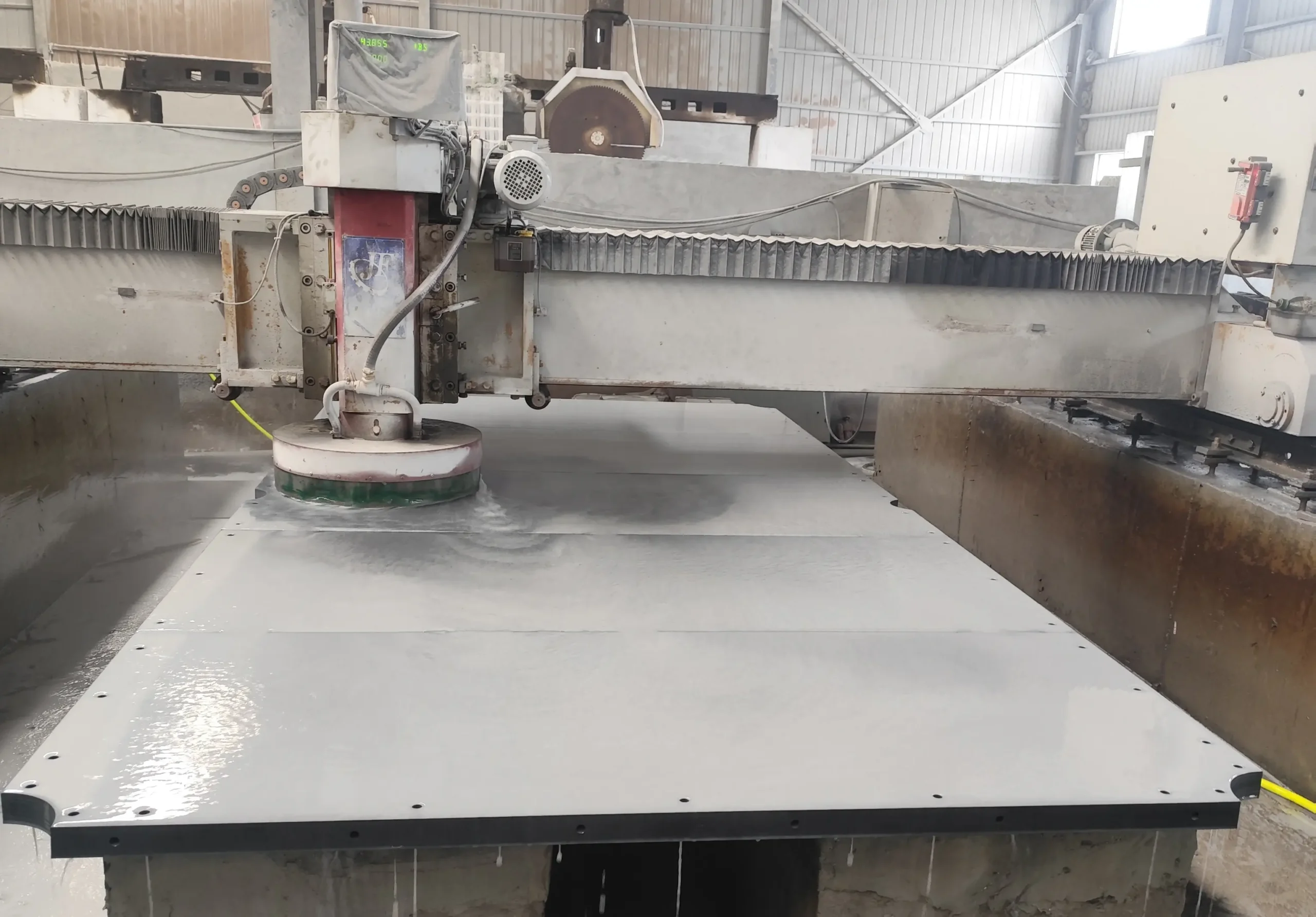 Diamond cup wheel grinding the surface of a grey slate panel