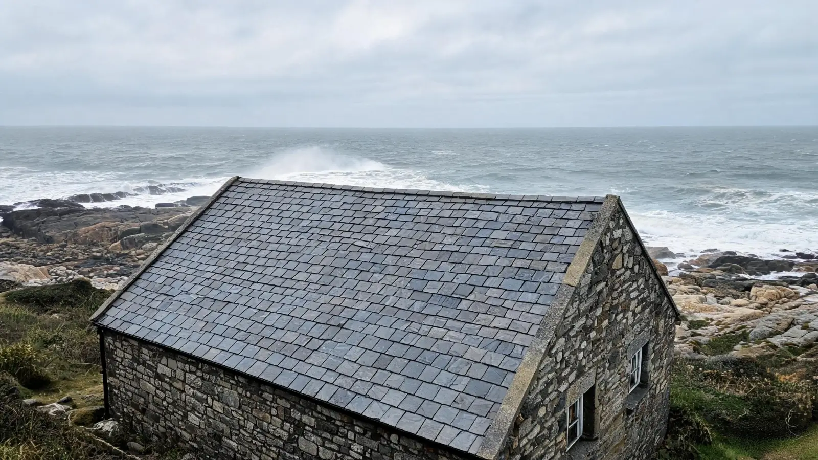 Coastal cottage with hook-fixed slate roof near the sea