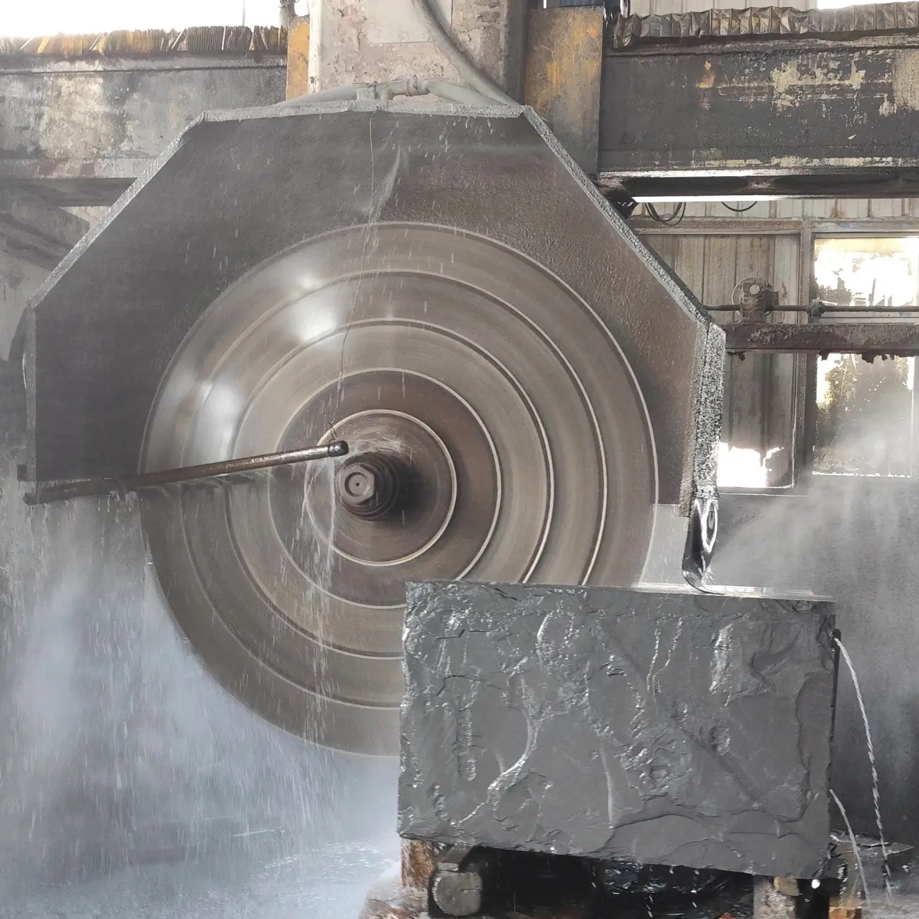 Diamond wire saw cutting a slate block in a processing workshop