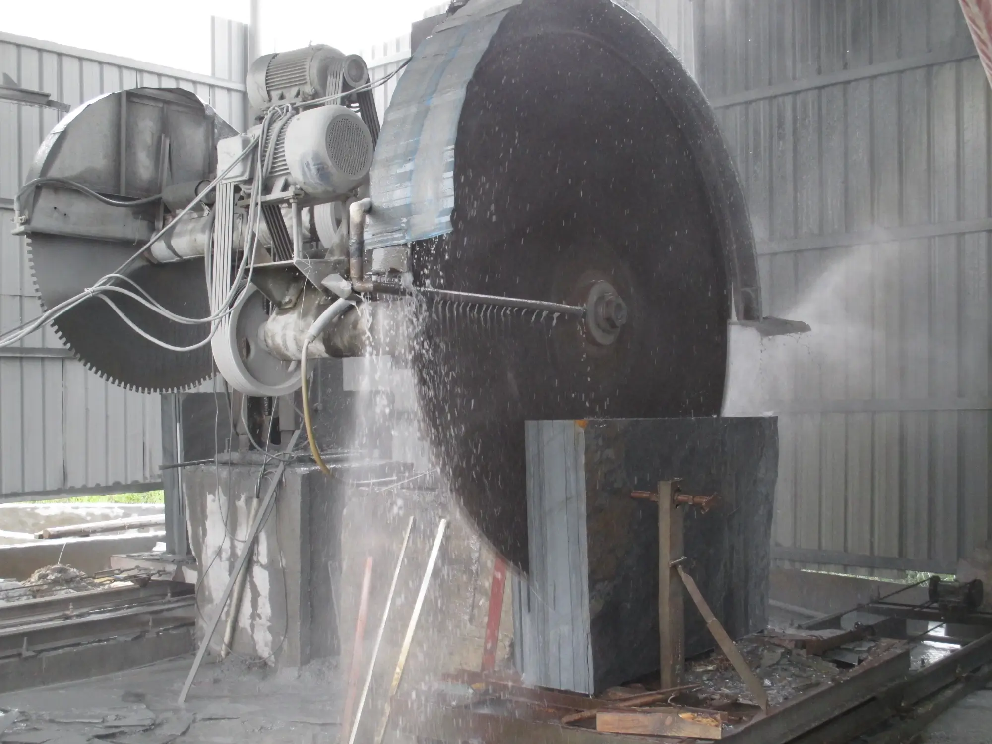 Saw cutting slate blanks for a billiard table bed Industrial saw cutting a large slate slab into oversized billiard bed blanks with water spray