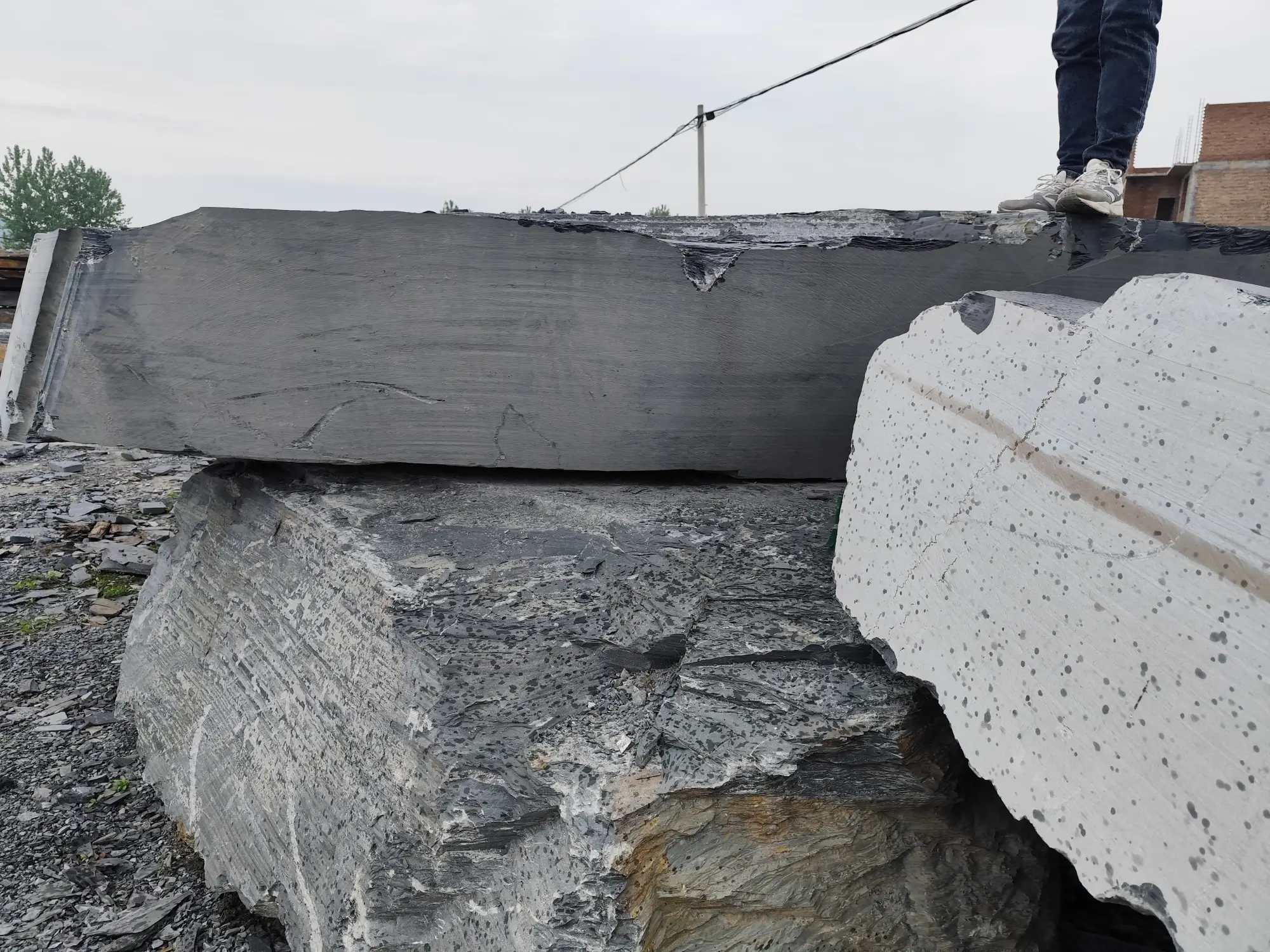 Rough grey slate blocks sorted and stacked in a processing yard