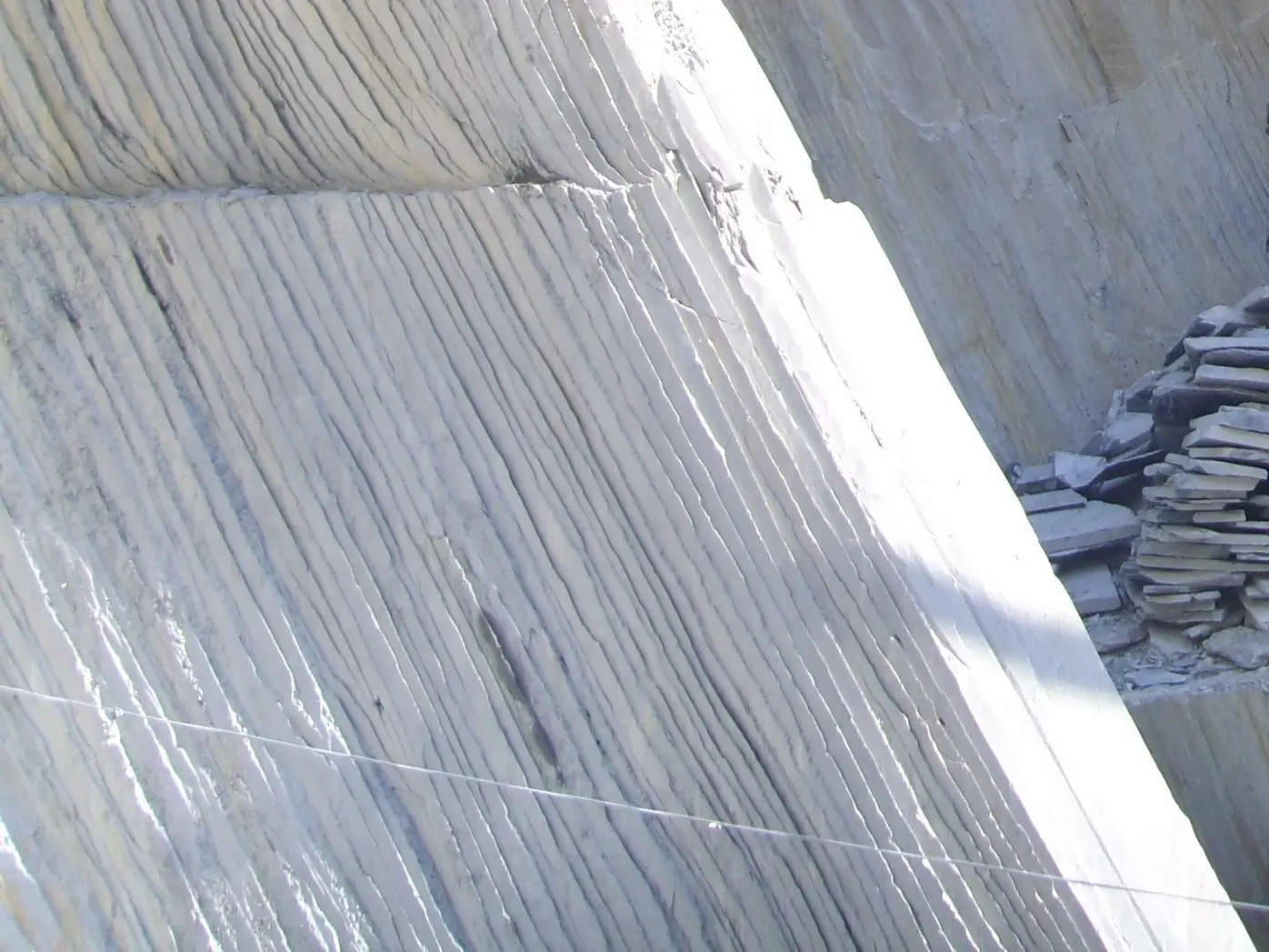 Close-up of natural slate rock strata showing layered grey bedding planes