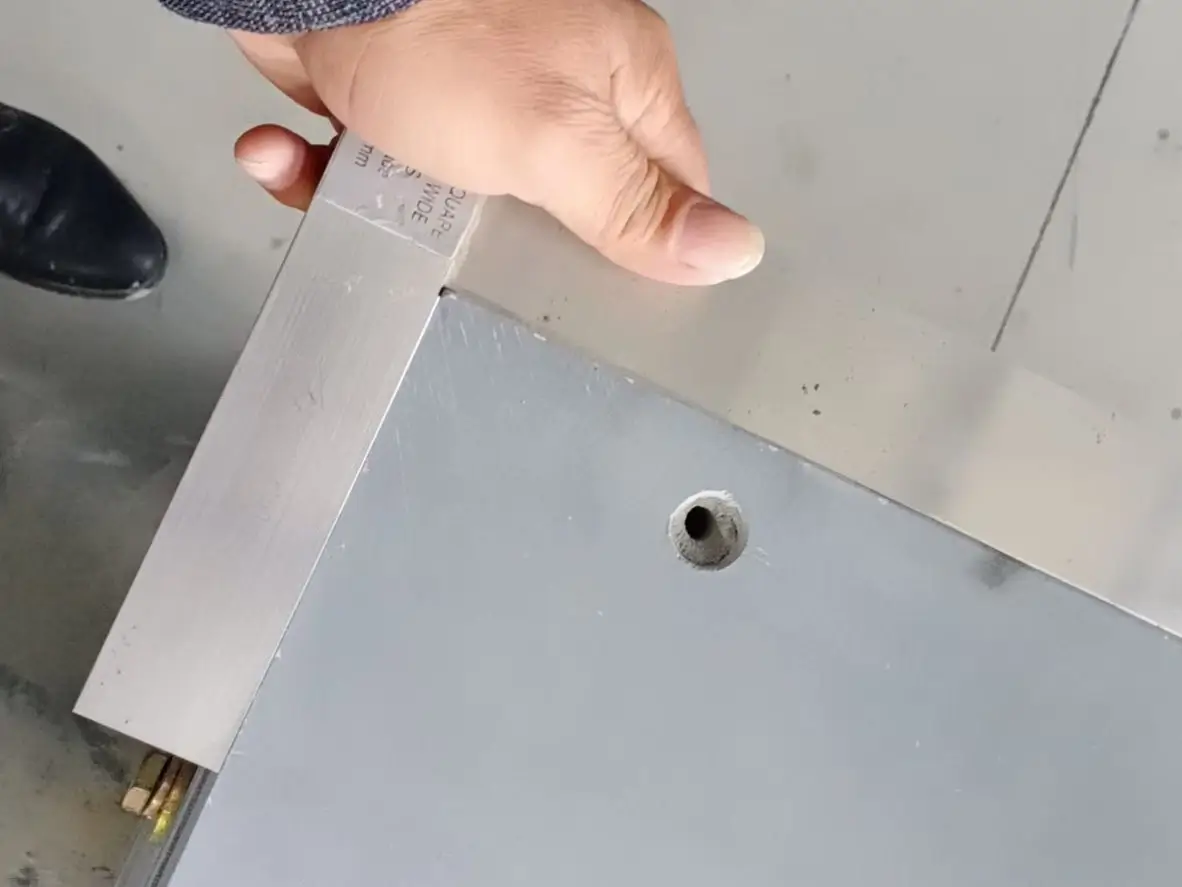 Jiujiang Slate Flatness & Dimensional Stability 1 A precision steel straightedge resting on a dark grey slate surface with a thin line of light visible at the edge, showing flatness measurement in a workshop