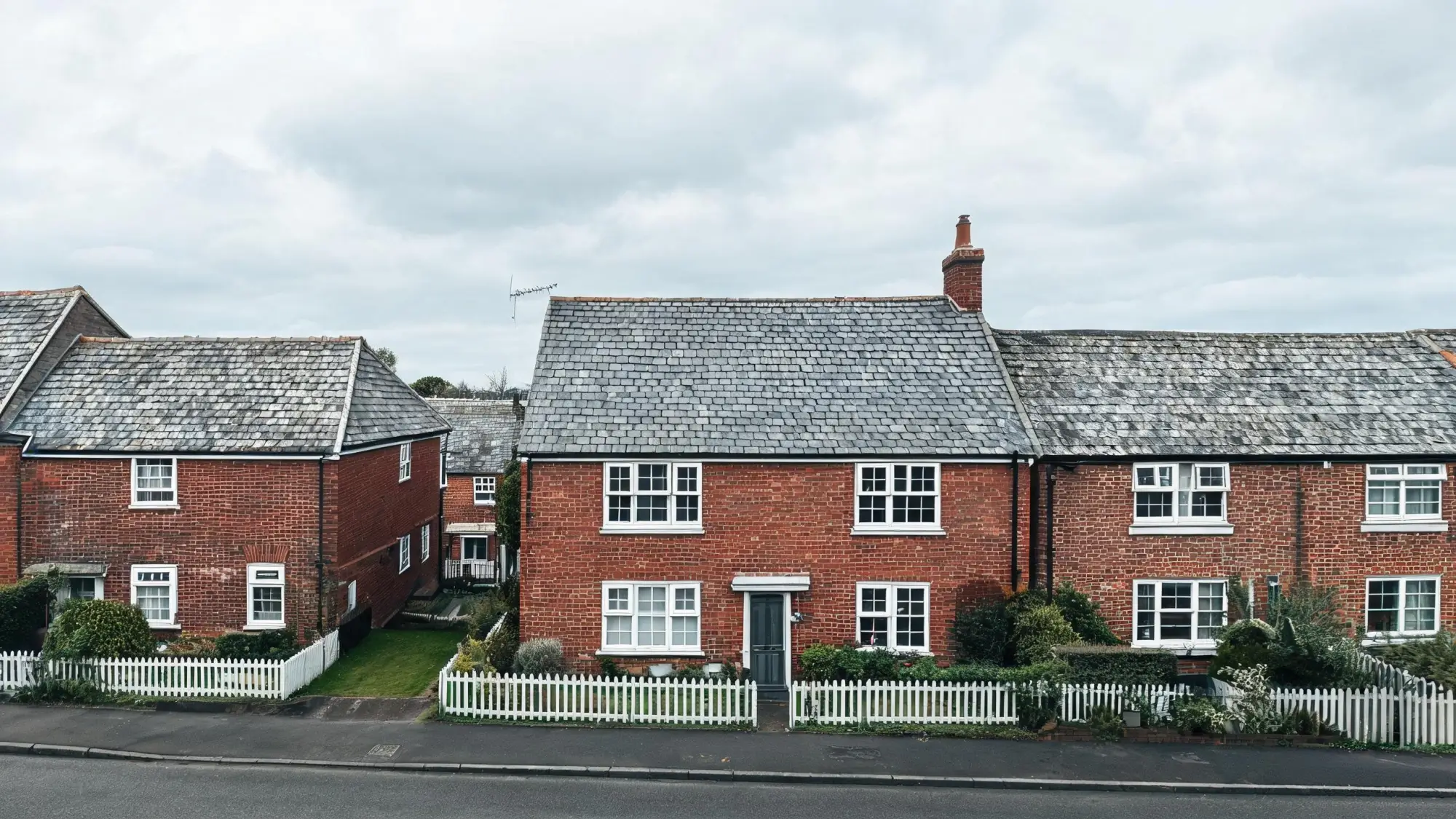 Grey slate roof on an English cottage with neighbouring slate roofs visible