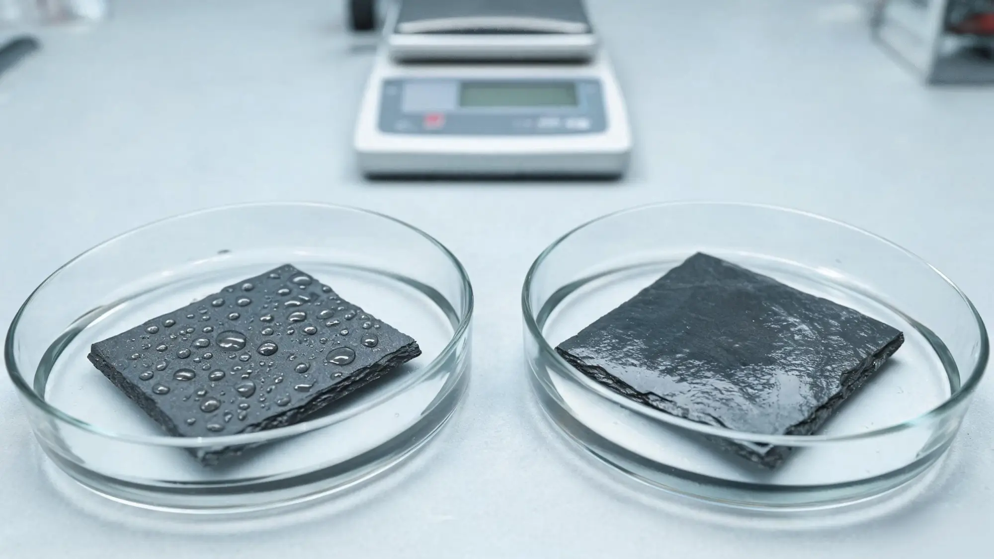 Jiujiang Slate Density 4 Comparison test on two slate samples: water beads up on one surface and spreads flat on the other
