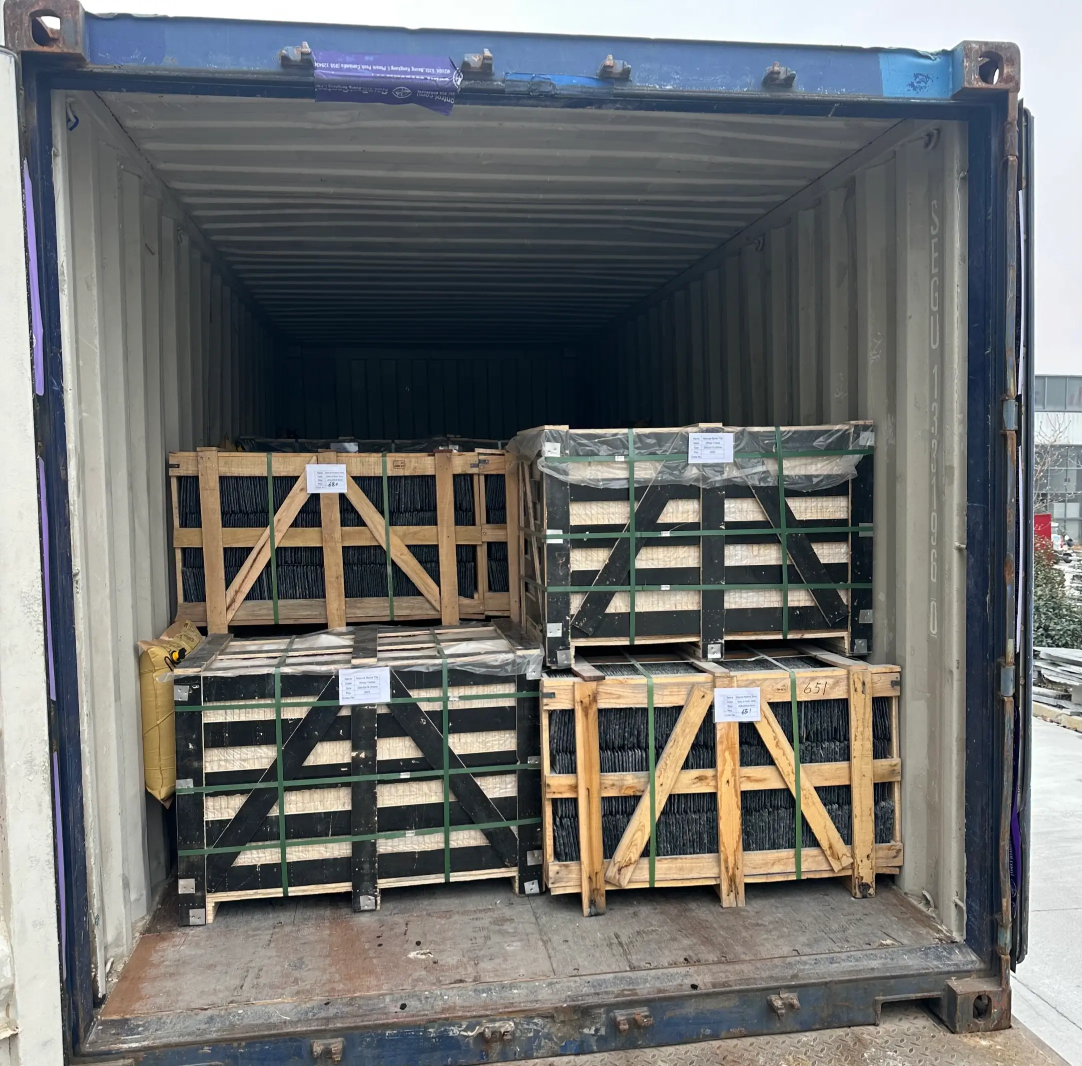 Jiujiang Slate vs Indian Slate 5 Twenty-foot shipping container being loaded with wooden crates of roofing slate at a factory