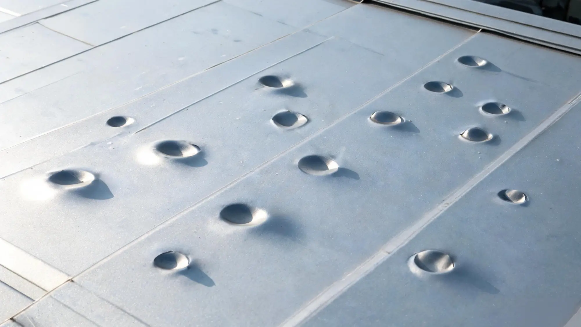 Aluminium metal roof panel with shallow dents after a hailstorm