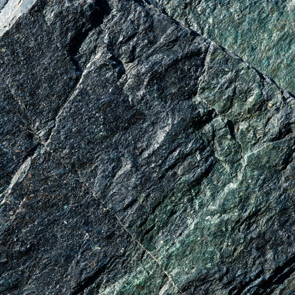 Macro view of freshly split slate surface showing mineral grains and natural cleft texture