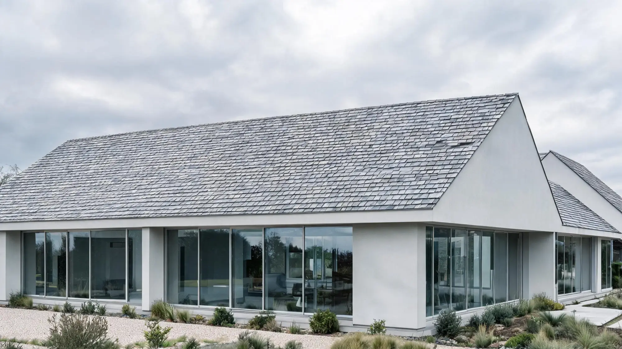Modern Lakeside Villa with Low-Pitch Slate Roof Modern minimalist villa with low-pitch grey slate roof and large glass windows