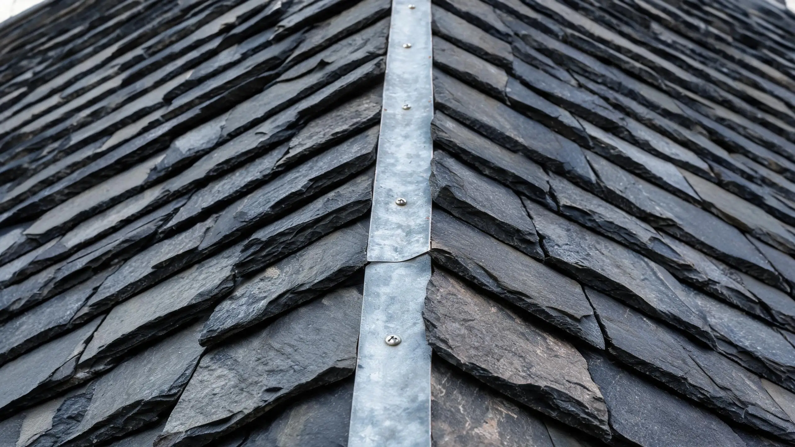 Thin zinc metal strip fixed along the ridge of a natural slate roof
