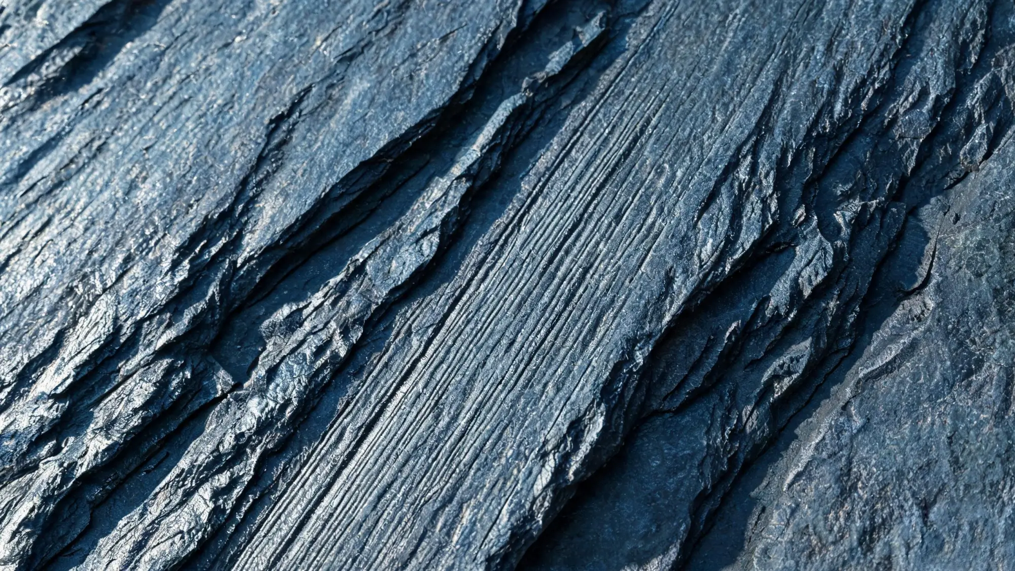 Macro close-up of a natural cleft slate surface showing fine ridged texture from hand splitting