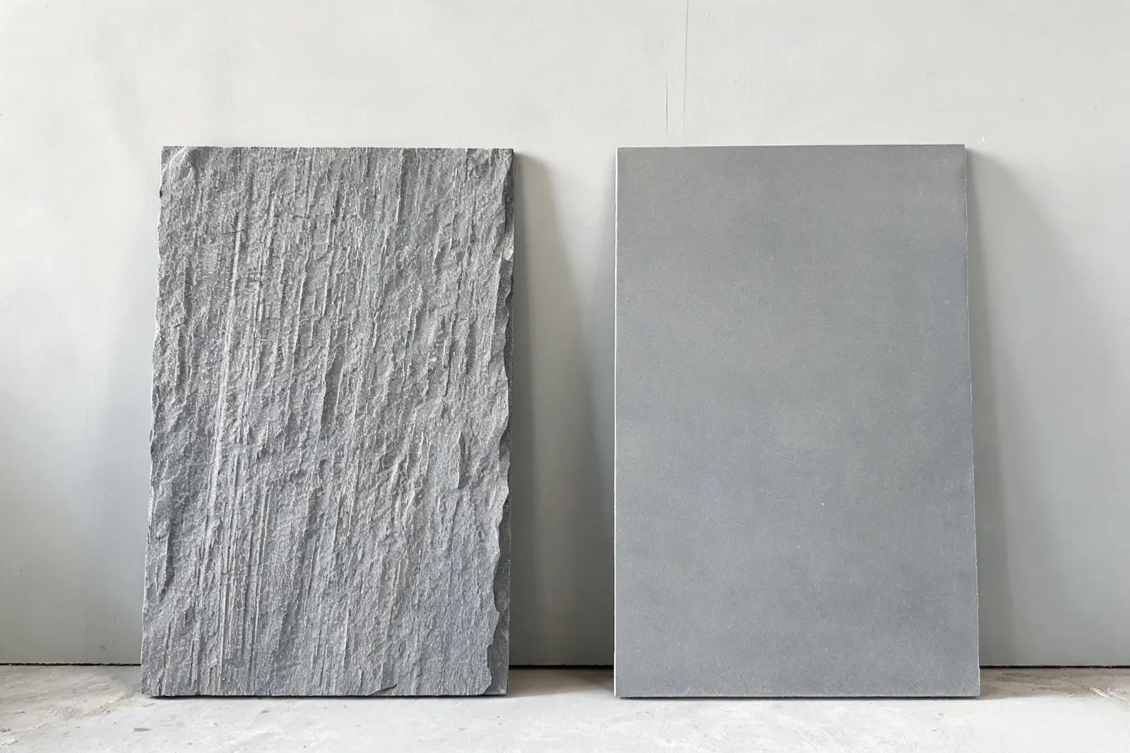 Rough sawn surface versus precision-ground surface on billiard slate Two grey slate slabs side by side, one rough sawn and one smooth ground