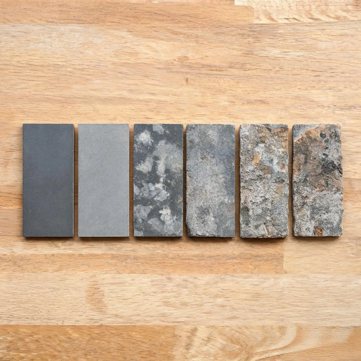Myths About Natural Roofing Slate 4 Several slate tiles of different grades arranged on a workbench showing quality variation