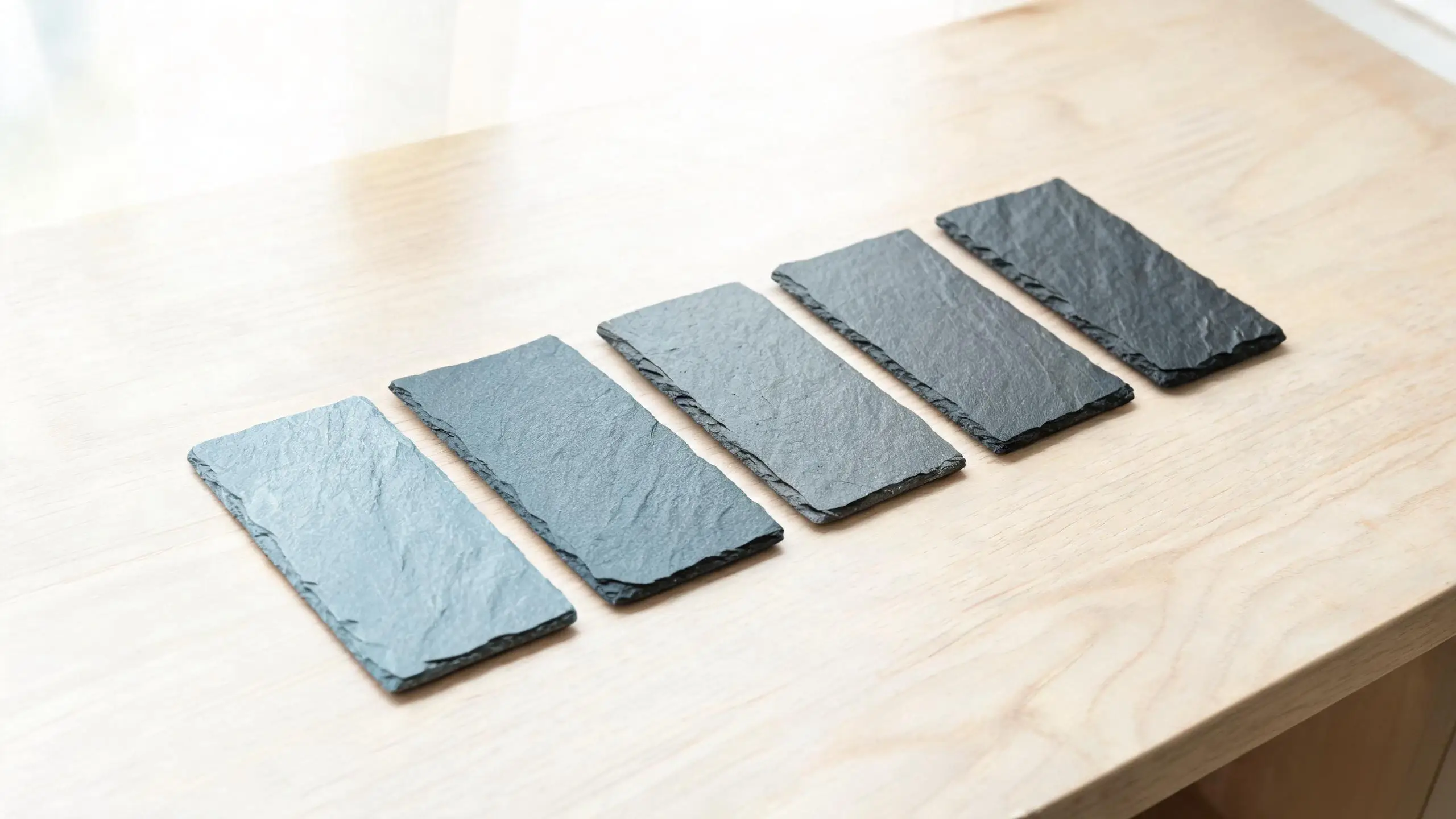 Roofing slate sample colour range in daylight Five roofing slate samples arranged from lightest to darkest to show the natural colour range in daylight