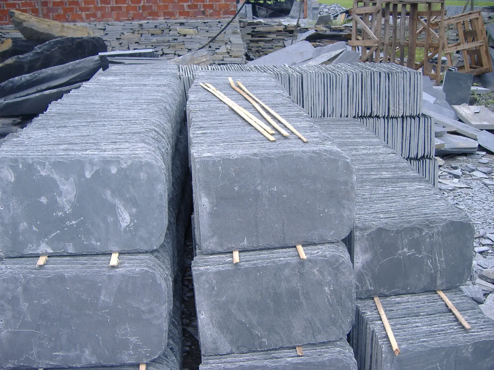 The Jiujiang Slate Industry 6 A neat stack of finished grey roofing slate tiles showing natural cleft surface texture