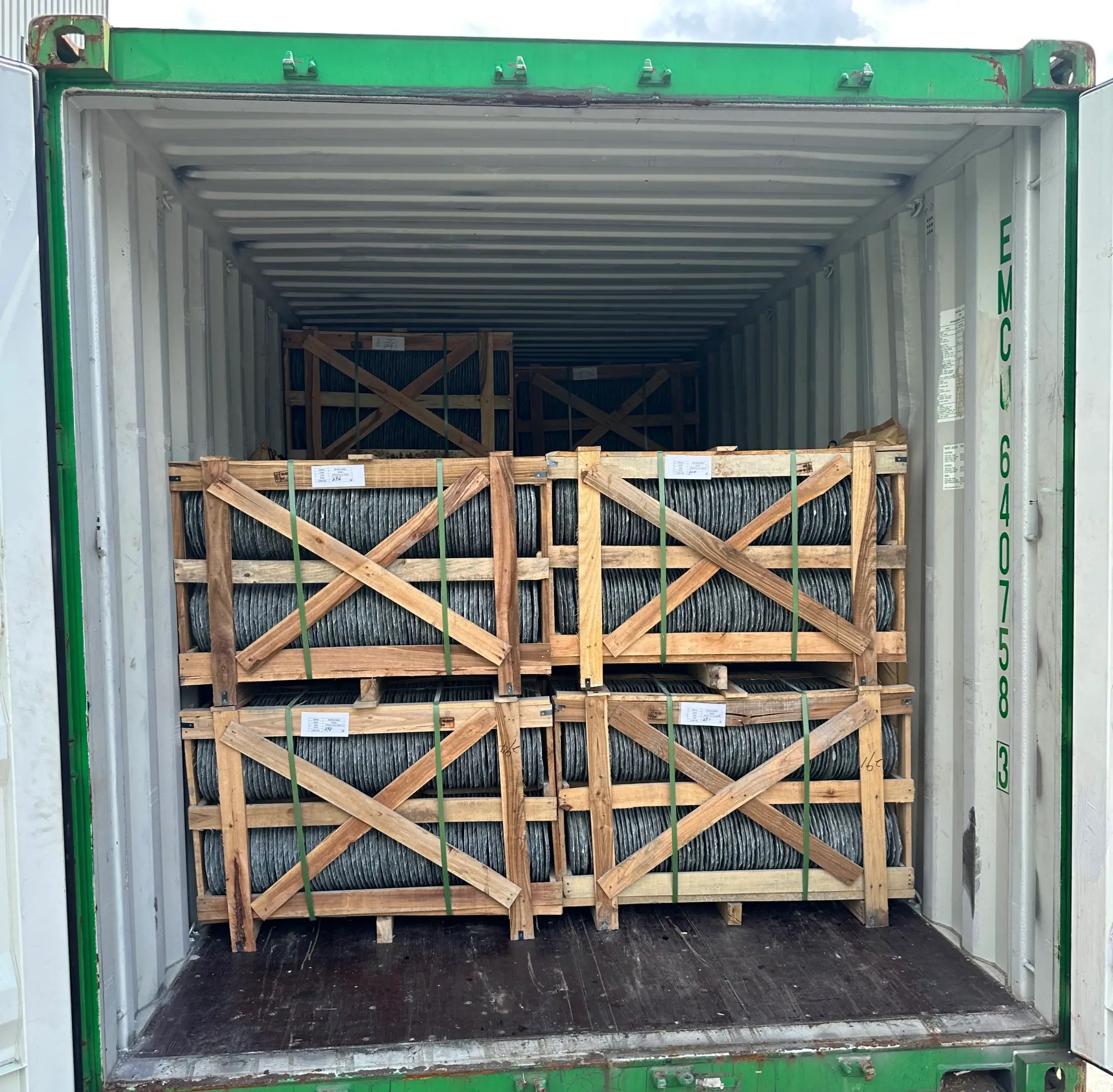 Shipping container being loaded with wooden crates of roofing slate at a factory loading dock