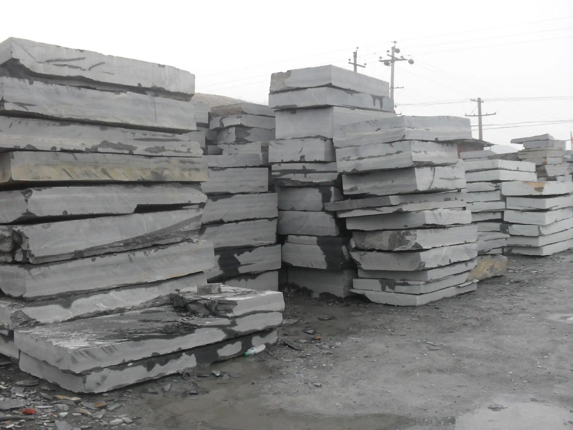 The Jiujiang Slate Industry 3 Rough slate blocks sorted and stockpiled in a quarry yard