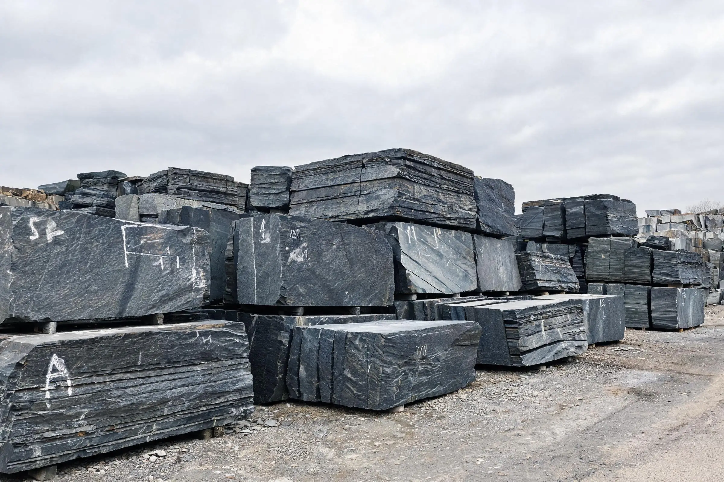 Slate blocks in the storage yard after extraction Raw slate blocks stacked in quarry storage yard with chalk identification marks