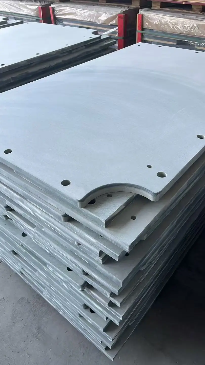 Row of precisely drilled fixing holes with clean chamfered edges in a dark grey slate panel