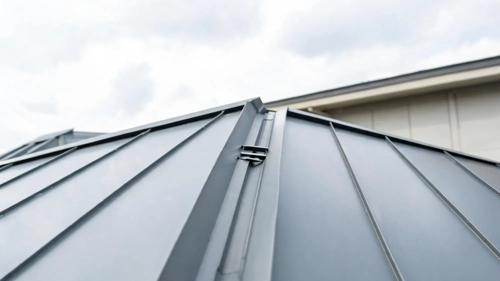 Close-up of standing seam metal roof showing raised seams and sliding clips