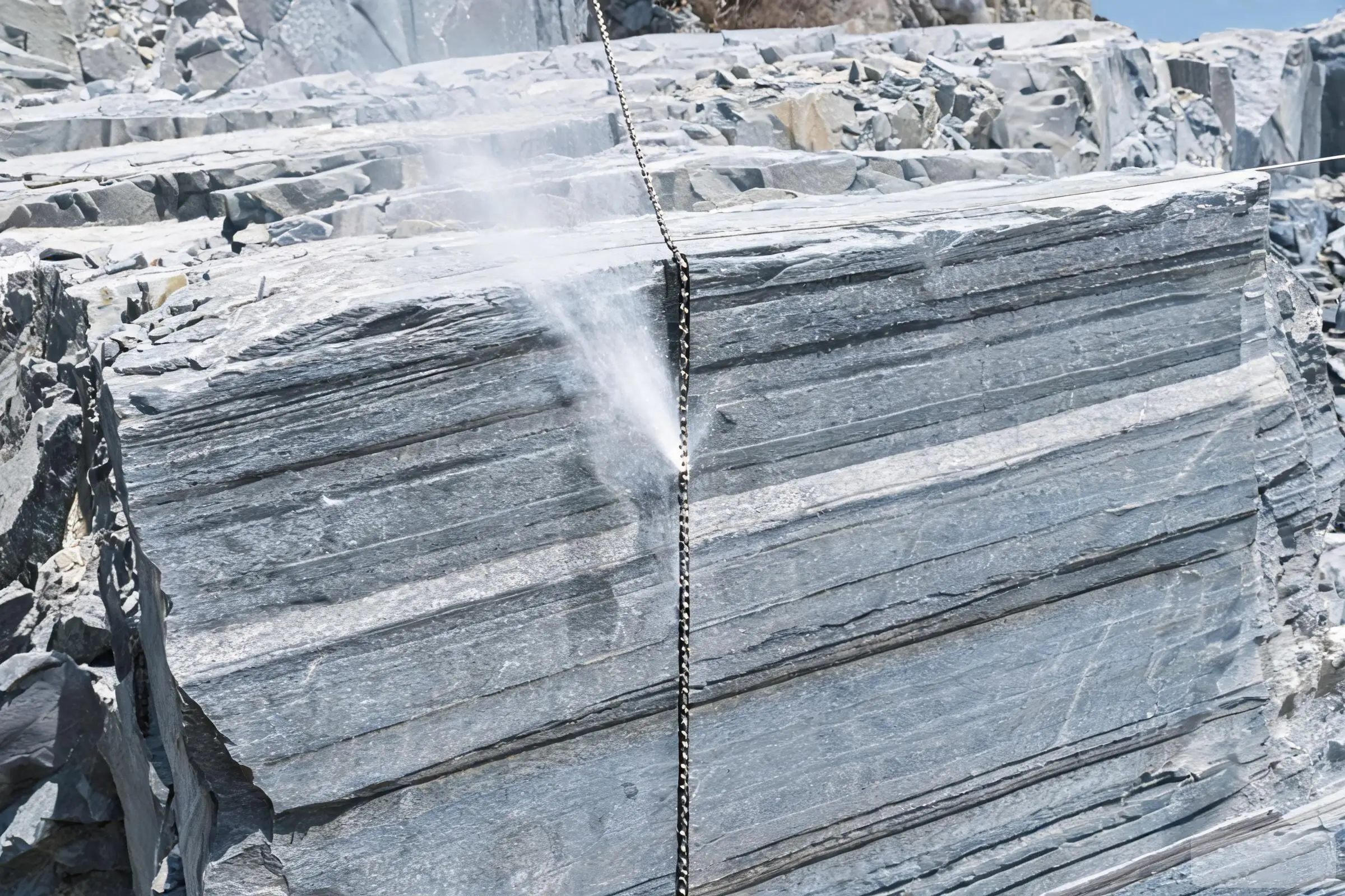 Wire saw cutting Jiujiang slate with diamond beaded cable Diamond wire saw cutting through grey slate in a quarry with water spray