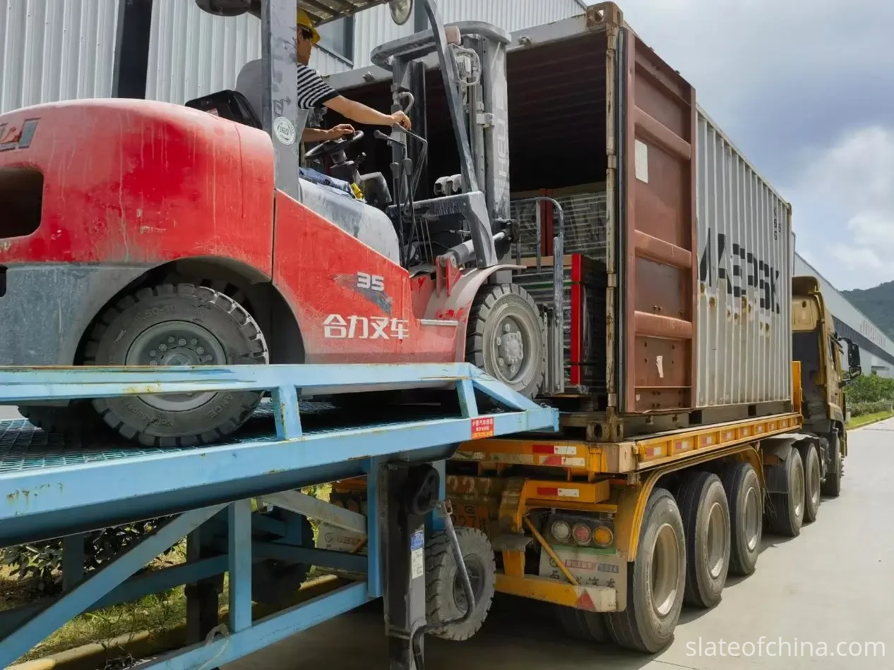 Export Wooden Crate Packing 6 Forklift loading palletized billiard slate stacks into a shipping container on a flatbed trailer at a factory loading dock
