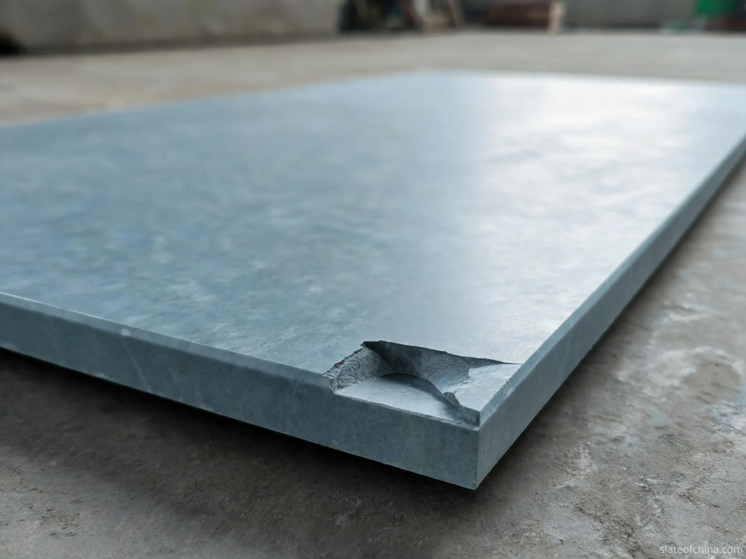 Common Billiard Slate Defects 2 Chipped edge on a thick billiard slate panel showing fresh fracture surface