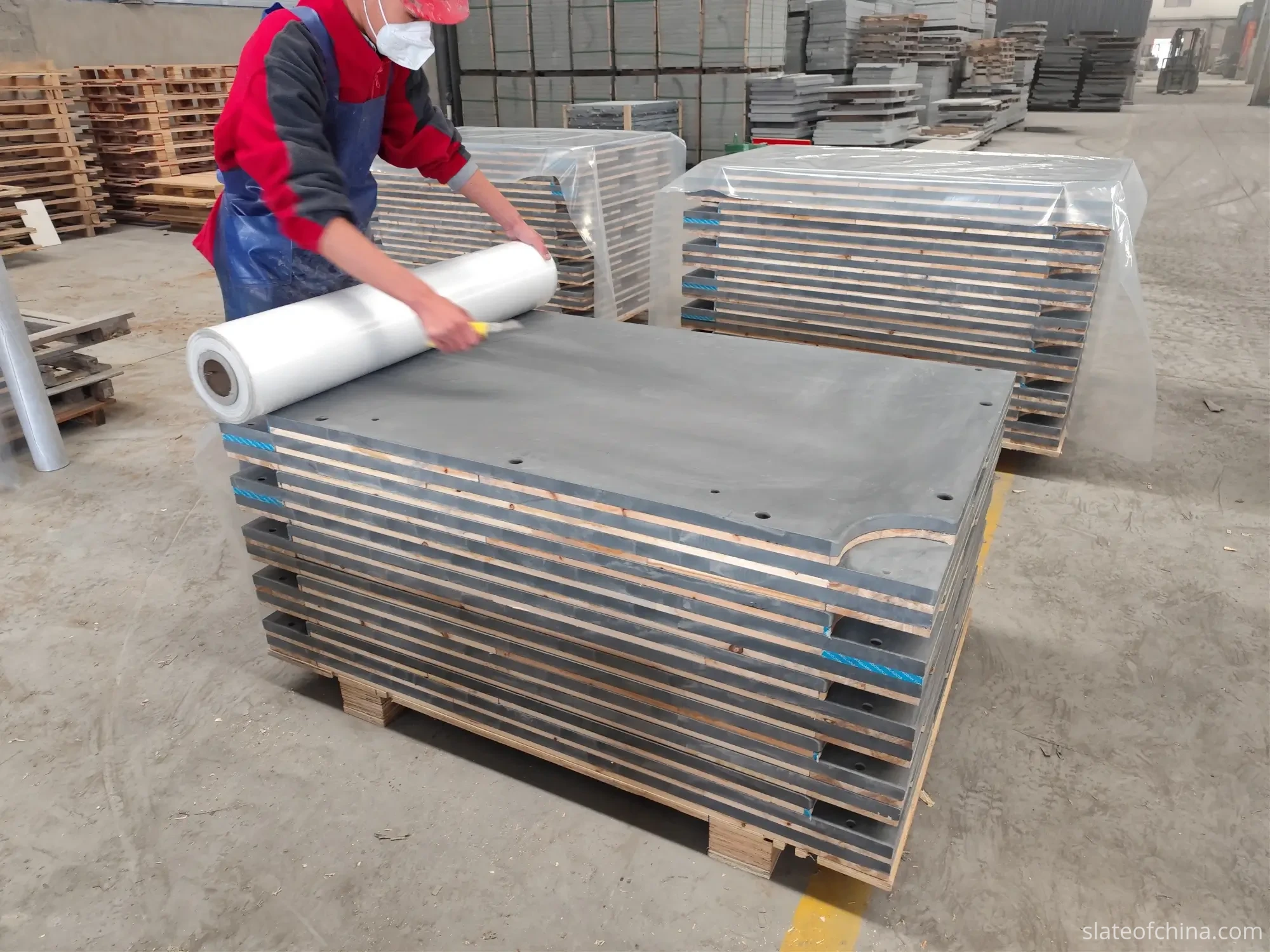 Surface Quality Inspection 6 Billiard slate panels stacked on a pallet with foam edge strips, being stretch-wrapped for export packing