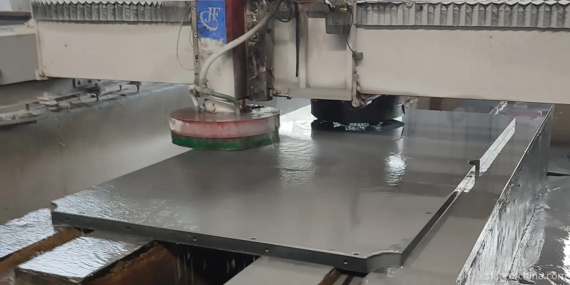 Billiard Slate Surface Grinding In The Factory Surface grinding machine working over a large billiard slate slab in the factory workshop, machining head positioned on the stone bed