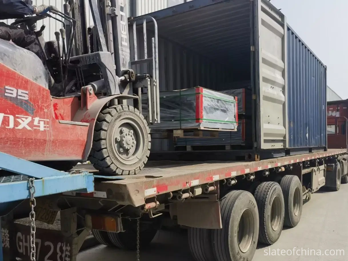 Billiard Slate Container Loading In Progress — Project Gallery Forklift easing a pallet of strapped billiard slate into a 20 ft container while packed pallets wait inside, at the loading dock