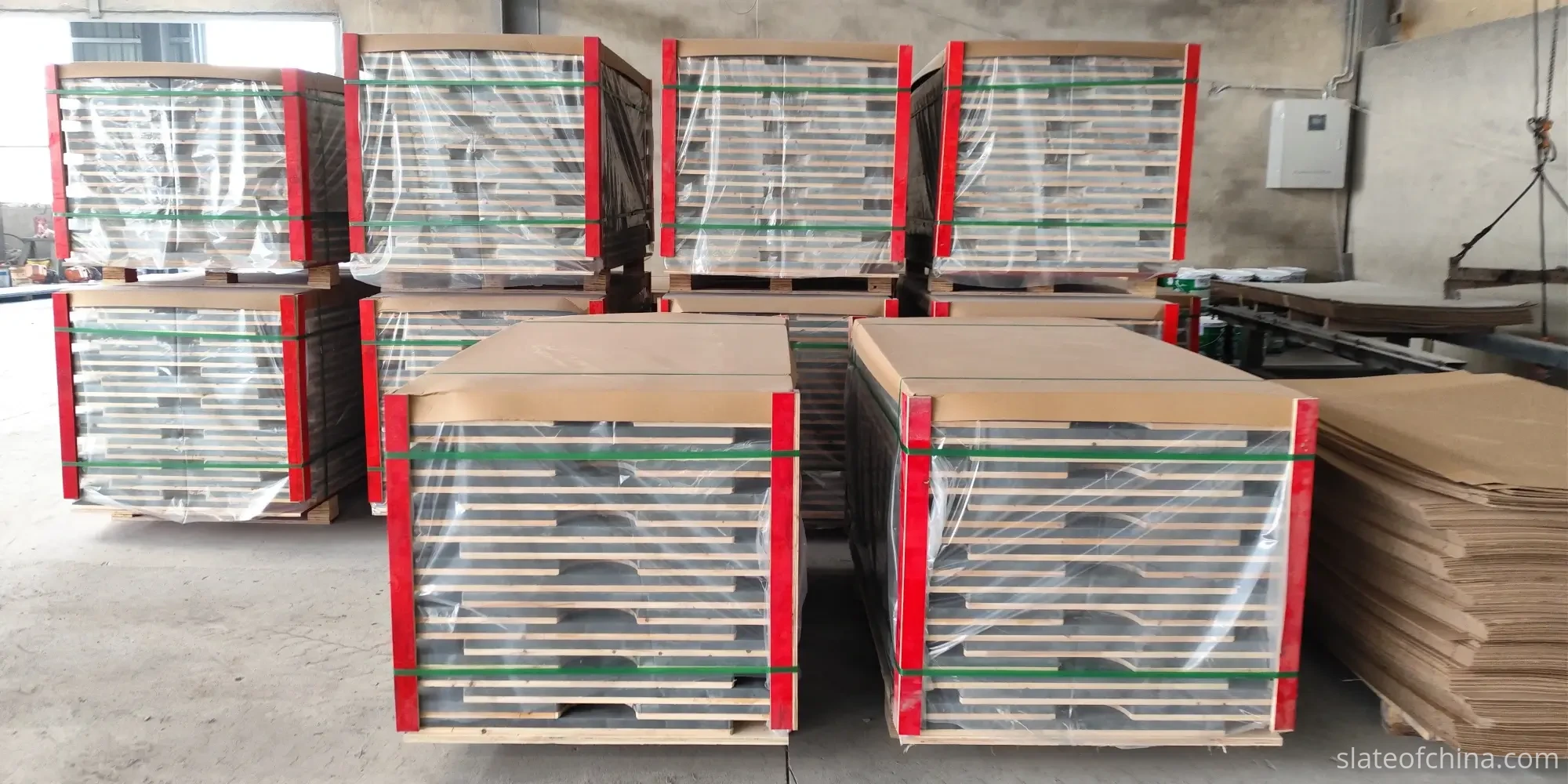 Billiard Slate Sets Stacked On Export Pallets Wrapped and strapped stacks of billiard slate sets on wooden export pallets with battens between layers inside a factory warehouse