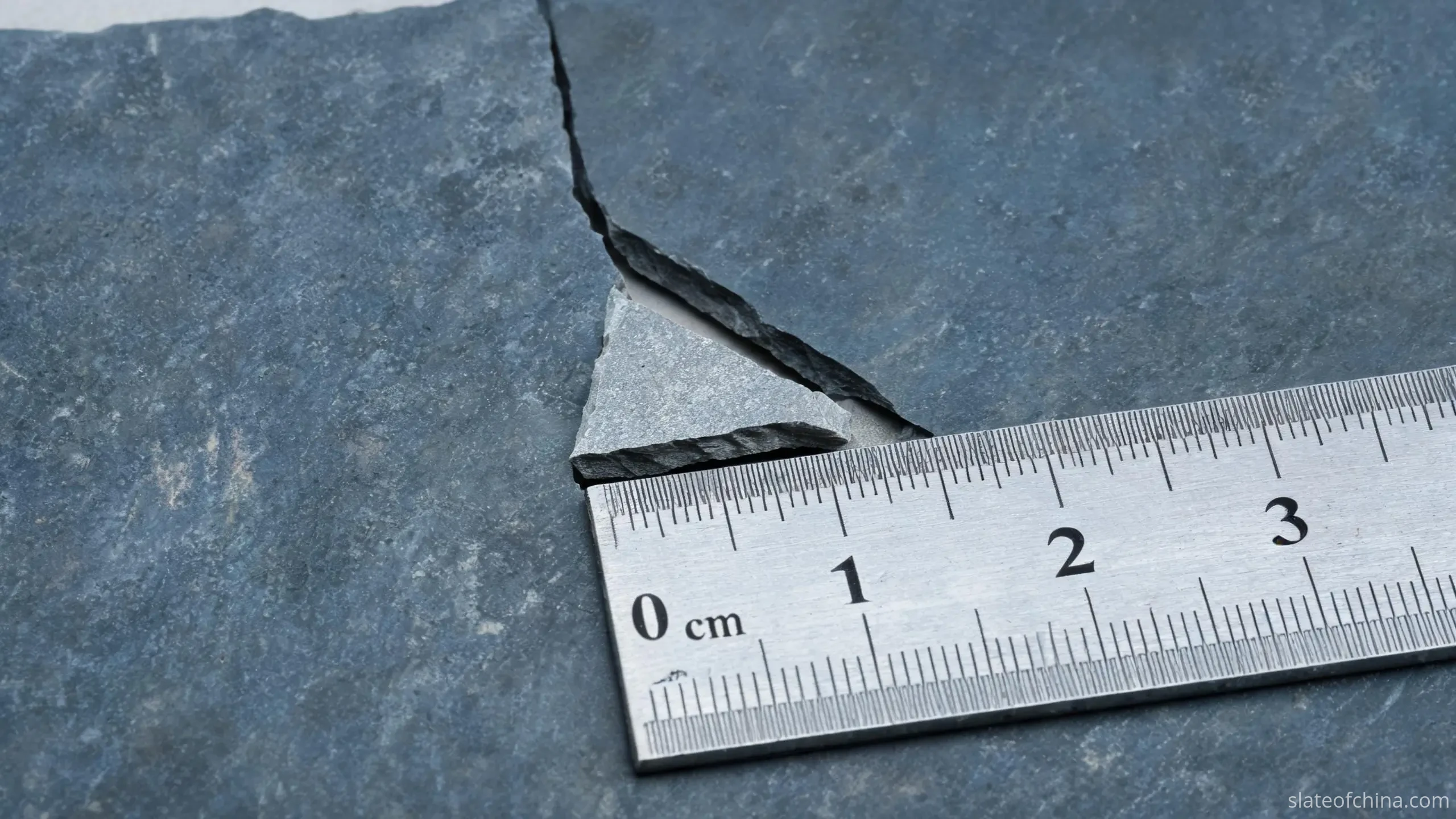 Chipped edge on a billiard slate panel showing the kind of transit damage that can make a machined piece unusable
