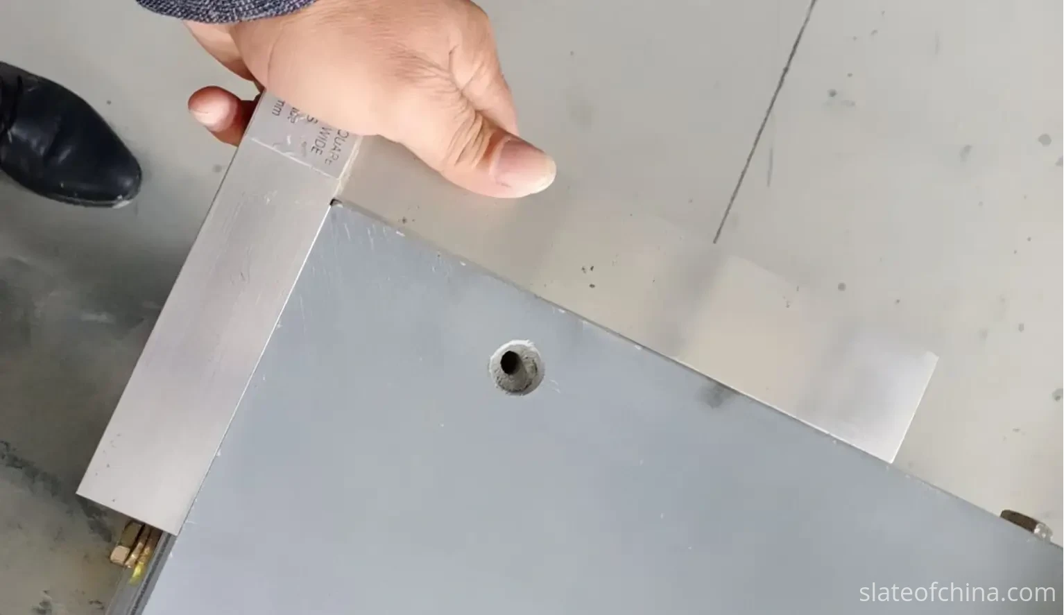 Engineer's square check of billiard slate edge geometry Engineer's square held against a billiard slate panel corner to check edge straightness and squareness