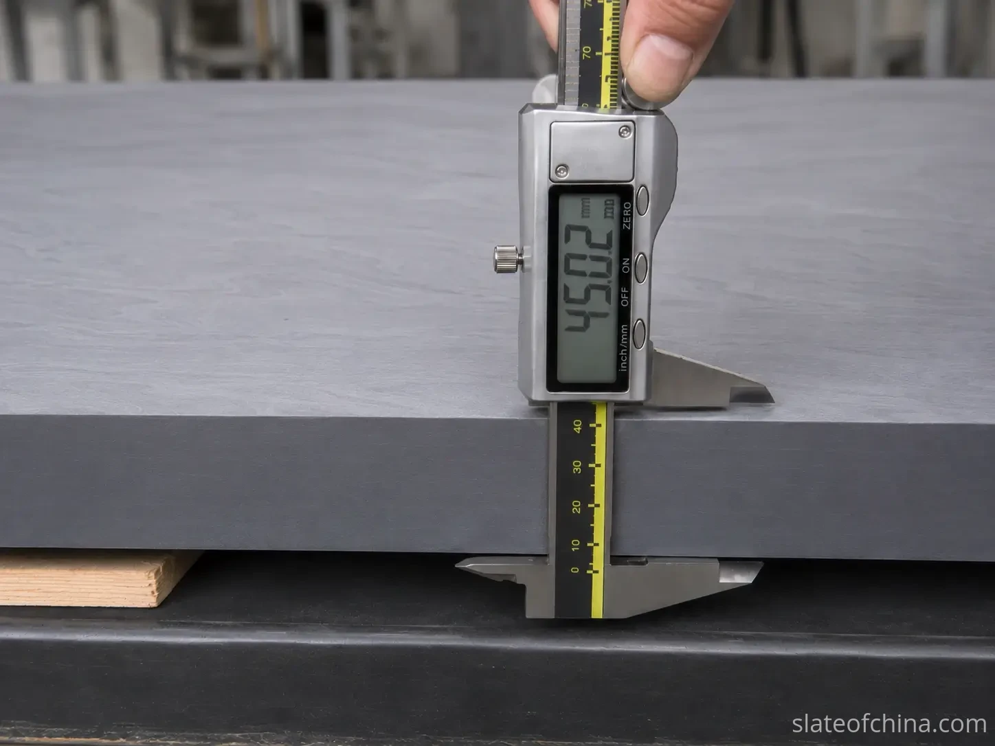 Billiard Slate Thickness Measurement with Digital Caliper Digital caliper measuring the thickness of a billiard slate panel at the factory, display reading 45.02 mm