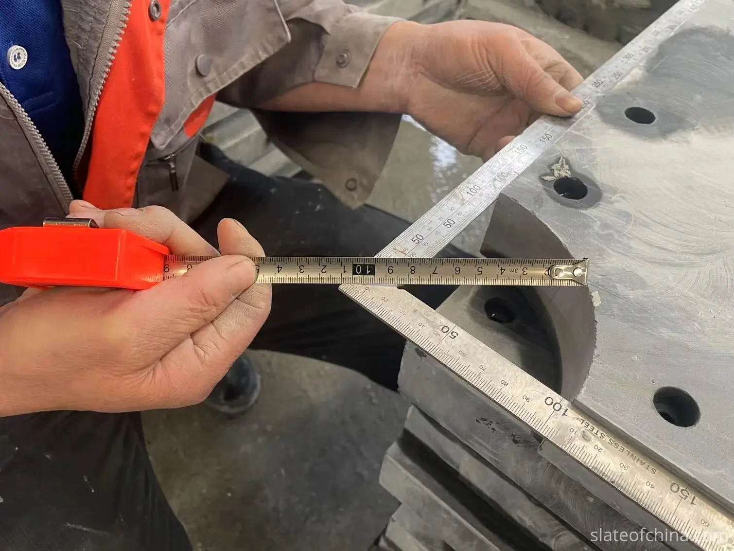 Pocket opening inspection with measuring tools Inspector measuring a machined slate panel with tape measure and set square