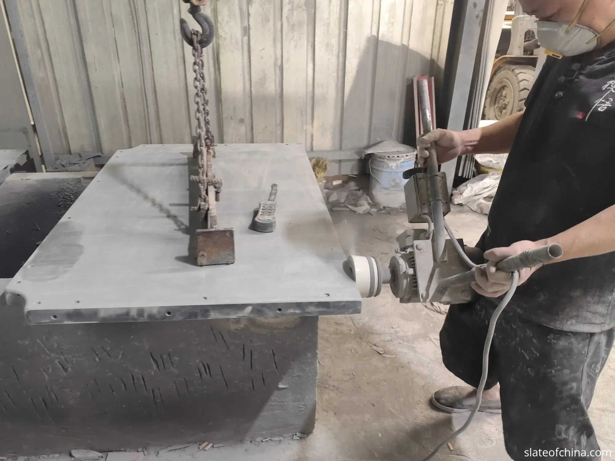 Custom Billiard Slate Manufacturing 3 Precision-machined straight edge of a large dark grey billiard slate panel on a factory workbench