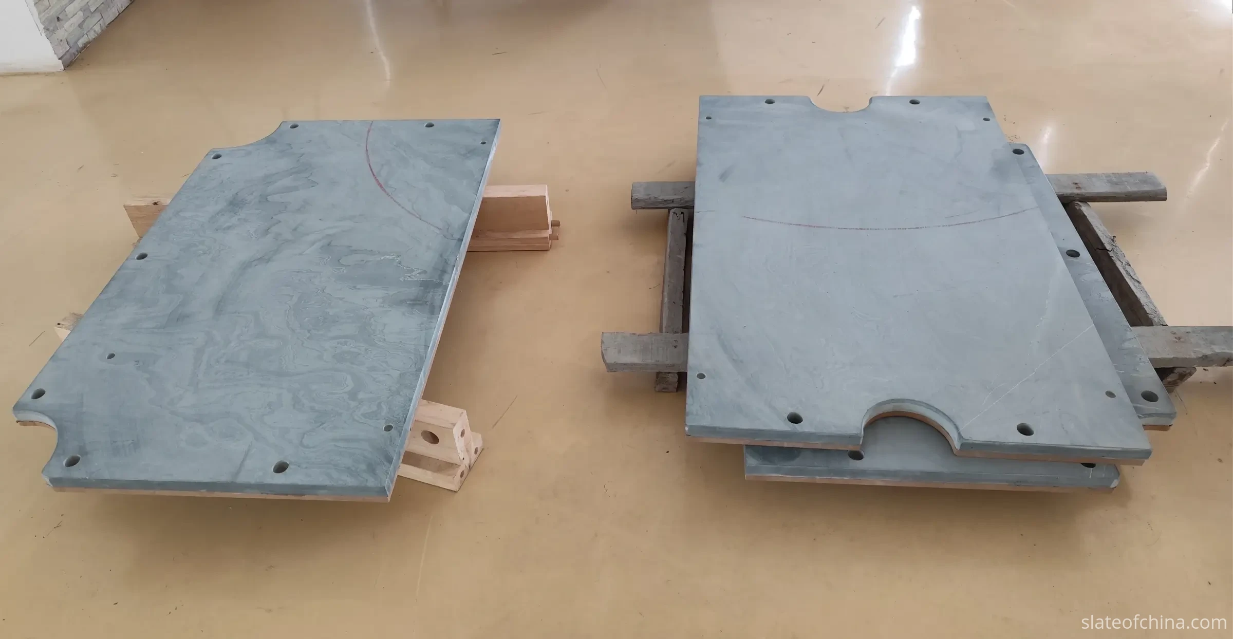 Billiard Slate Panels Staged for Inspection Billiard slate panels staged on wooden support blocks in a factory inspection area