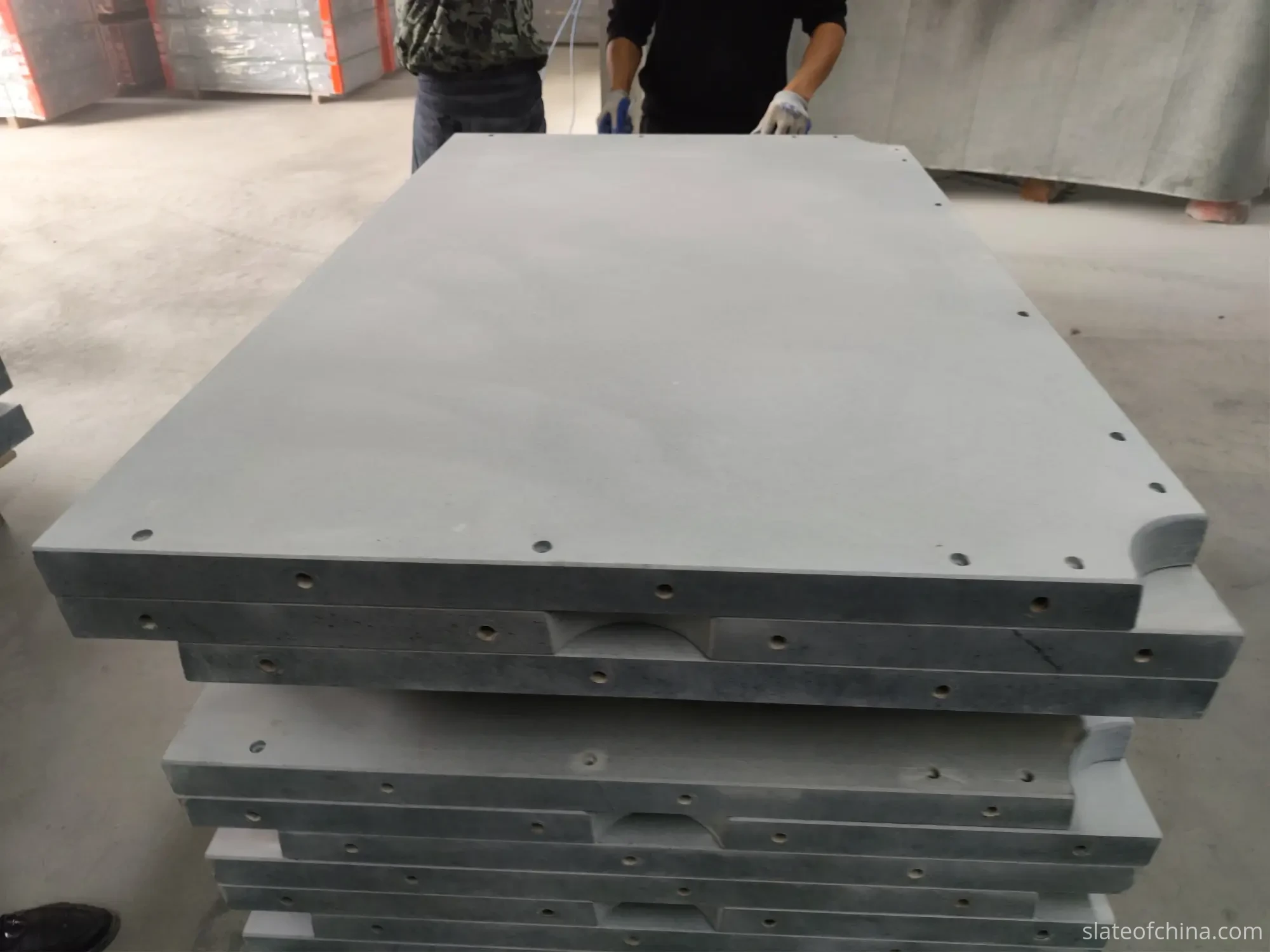 Ground slate surface texture and panel edges Stack of ground slate panels showing uniform matte surface texture and solid stone edges