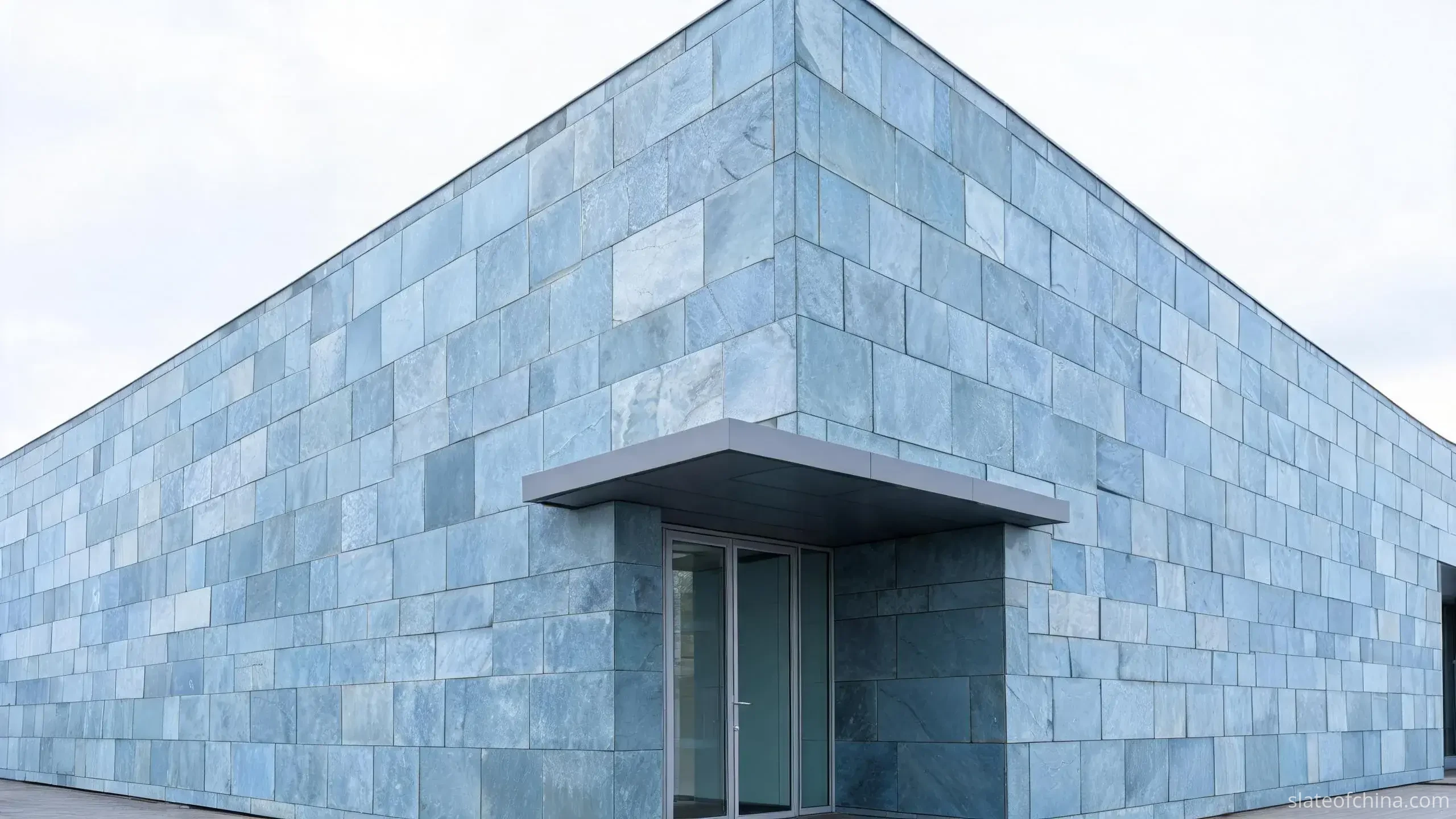 Jiujiang Slate for Outdoor Architecture 2 Illustrative close view of a commercial building podium clad in cool blue-grey slate cladding panels with open drained joints at an entrance corner