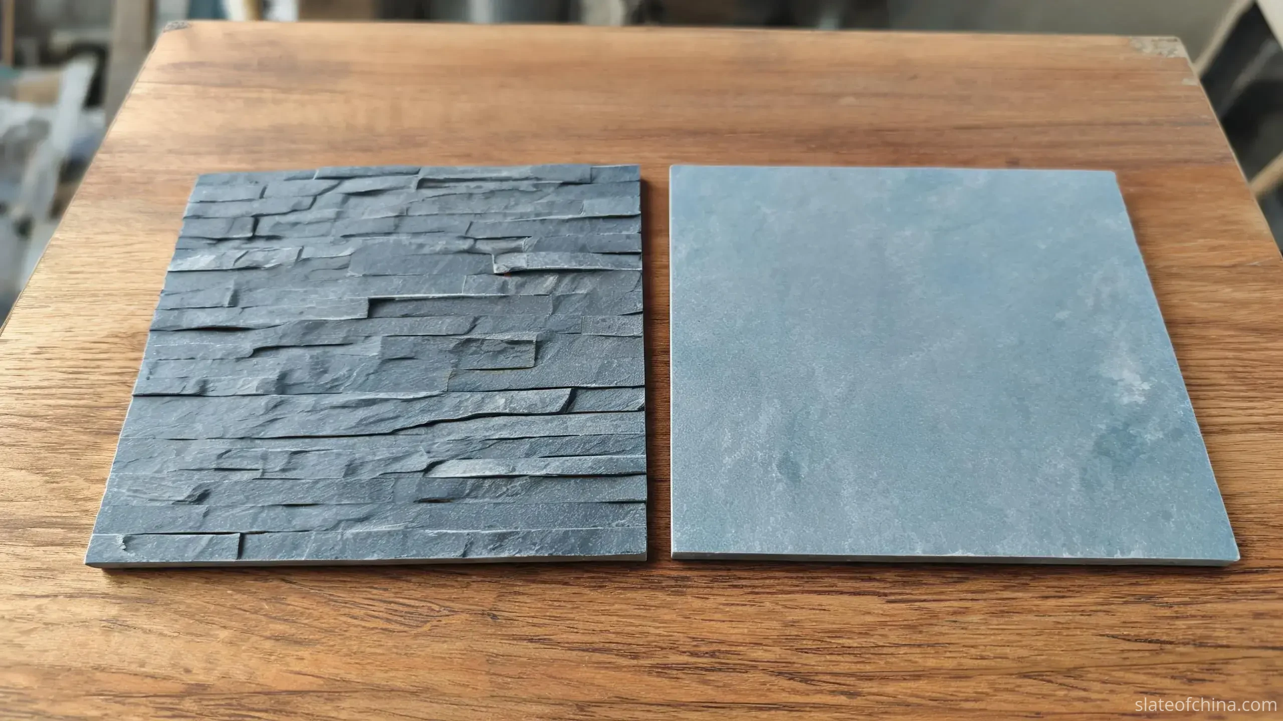 Jiujiang Slate Wall Cladding 2 Two slate wall cladding samples side by side on a workbench, left piece with natural cleft textured face, right piece with smooth dressed honed face, cool blue-grey tones