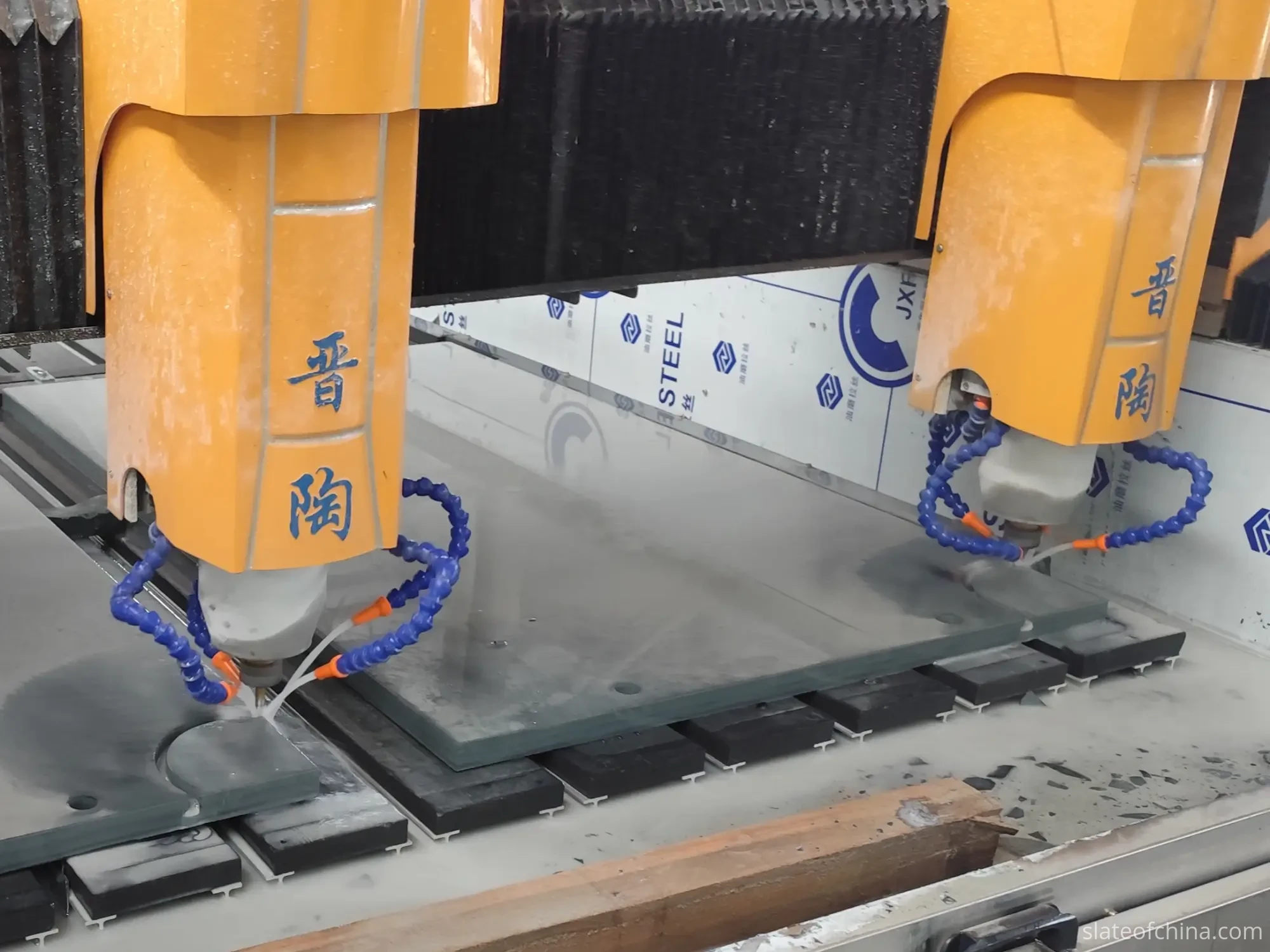 CNC pocket opening machining on a billiard slate panel CNC machine with dual spindles machining a grey slate panel on the worktable