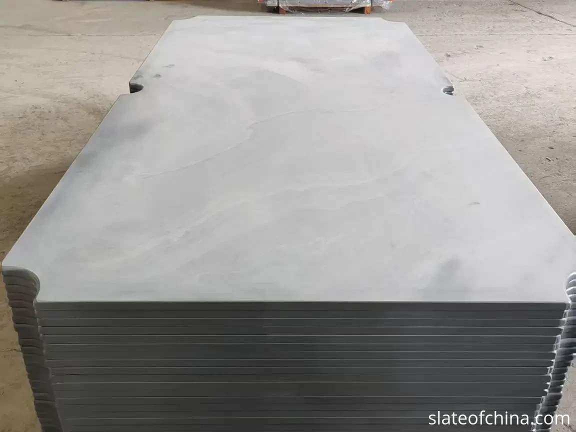 How to Choose Billiard Slate 2 Finished billiard slate panels stacked flat in a warehouse showing the smooth ground playing surface
