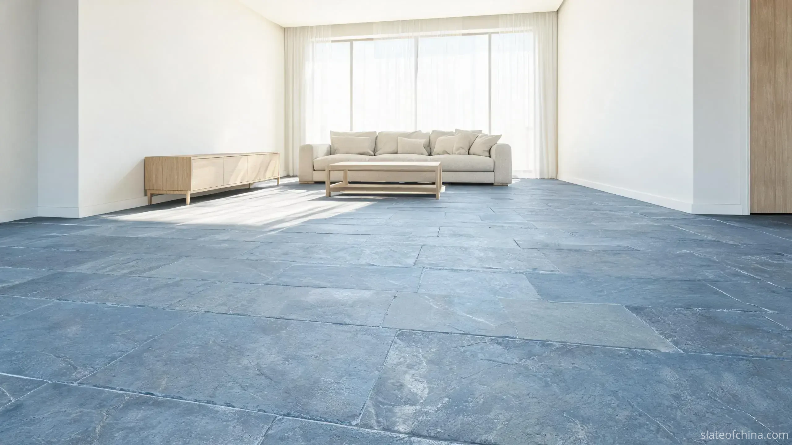 Slate Flooring vs Other Stone Flooring 4 Bright living room with a full floor of natural blue-grey slate tiles, pale walls, oak sideboard, linen sofa and large window daylight