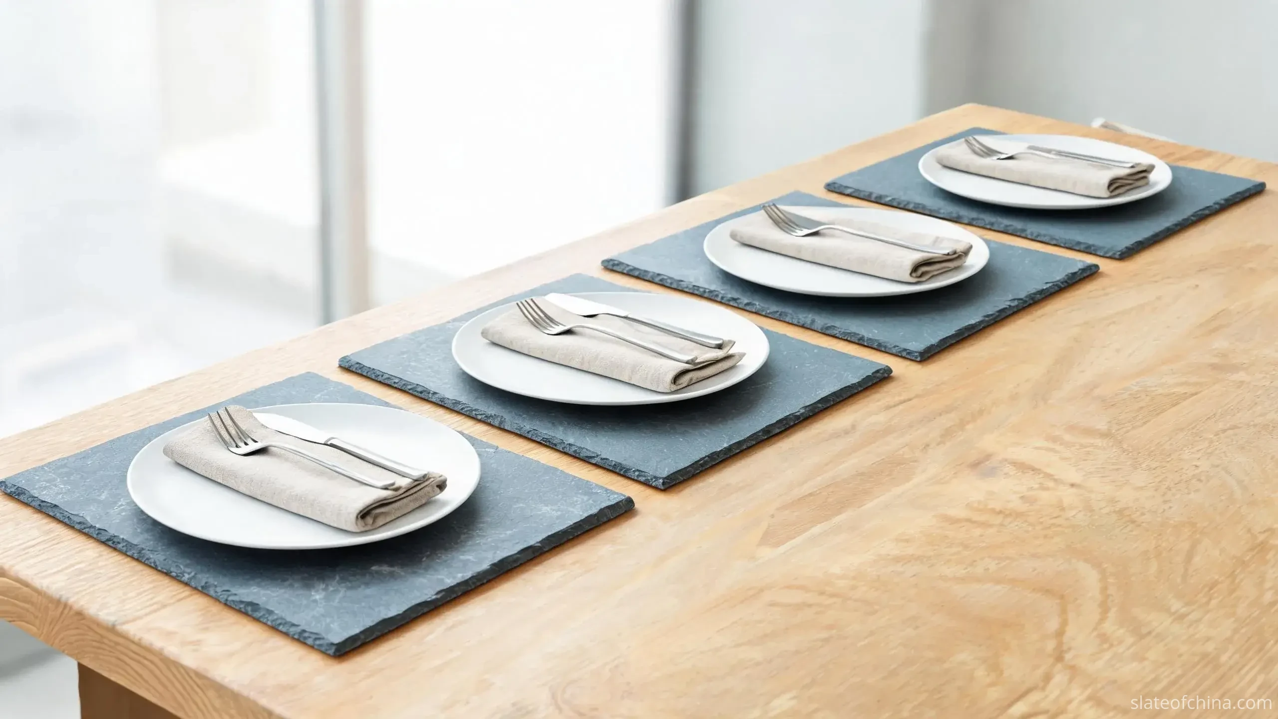 Slate Placemats & Tableware Accessories 1 Illustrative view of rectangular blue-grey slate placemats holding white plates and linen napkins on a light oak dining table